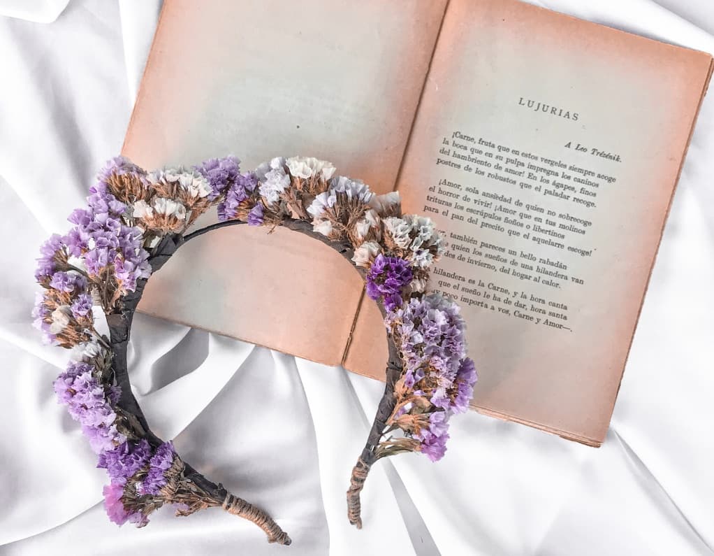 Dried flower headband in lavender and pink resting on an open book