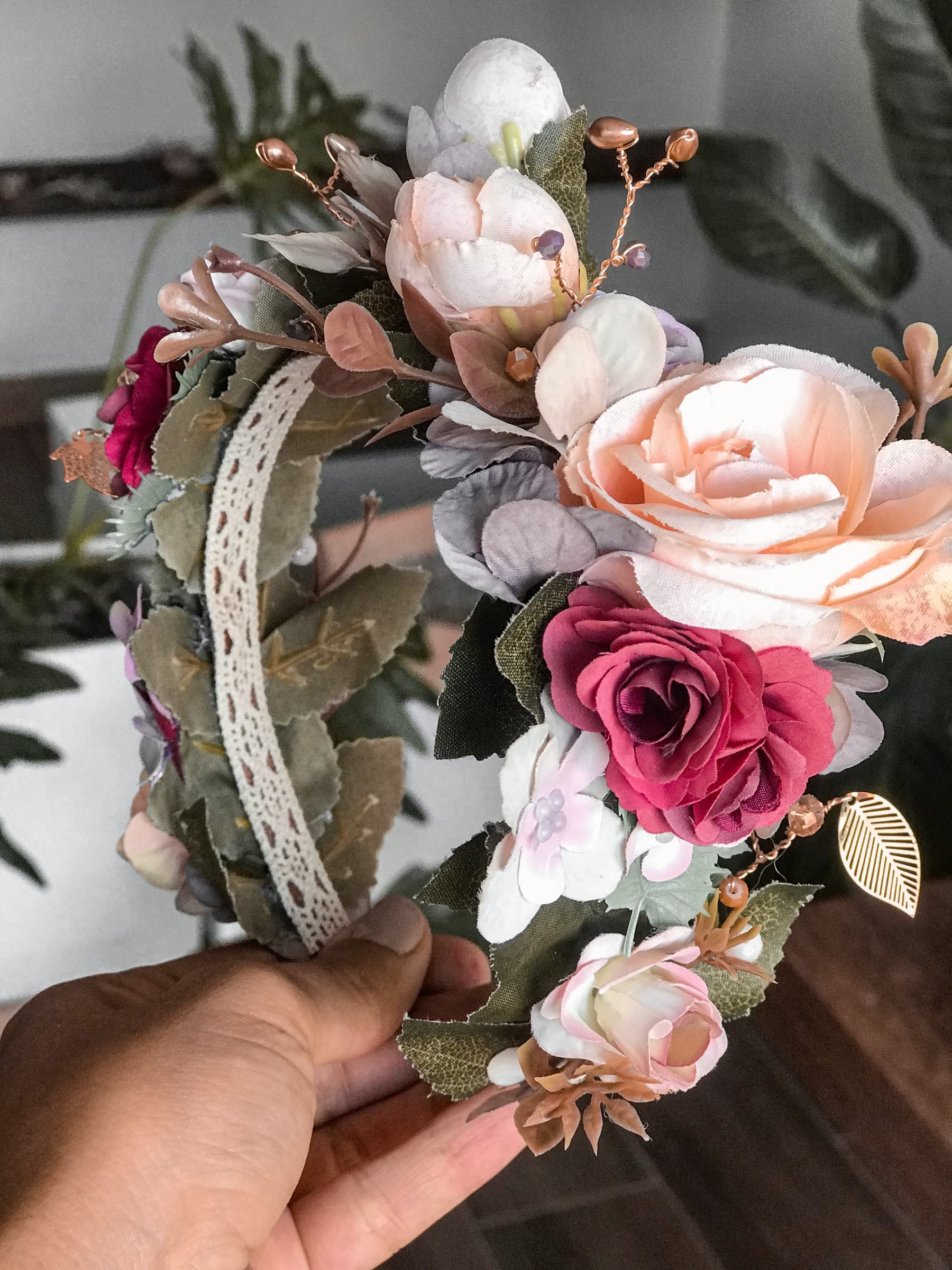 Hands shaping a flower crown of roses and peonies in the studio