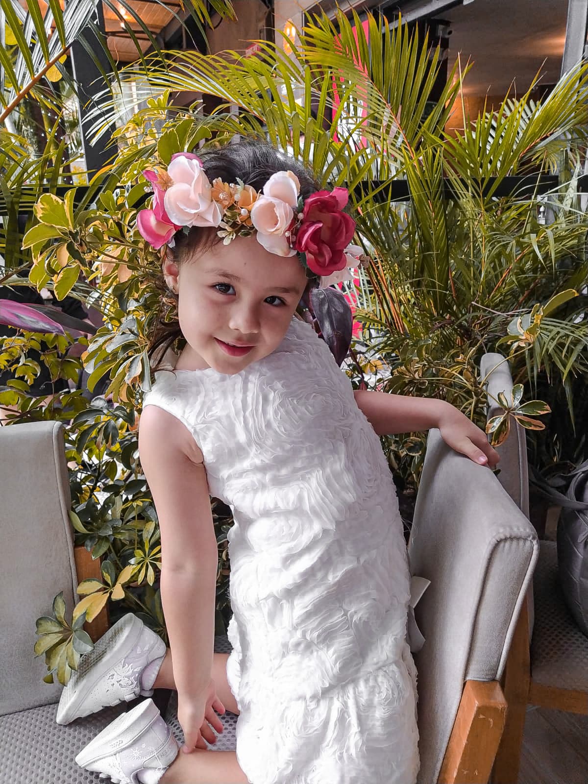Flower girl wearing a crown of roses and seasonal blooms