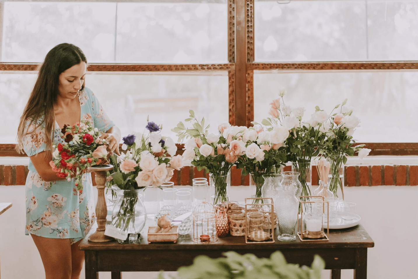 Daniela styling a table of bud vases and seasonal stems for a celebration